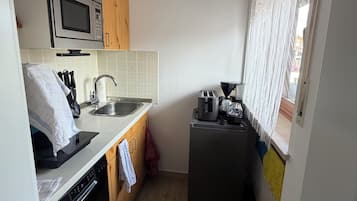 Eine kleine Küche mit Mikrowelle, Toaster und Geschirrspüler.
