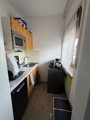 A compact kitchen with a microwave, toaster, and dishwasher.