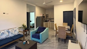A modern living room with a sofa, armchair, coffee table, and dining area. - Vacation home with a private pool and close to the beach (Jacó)