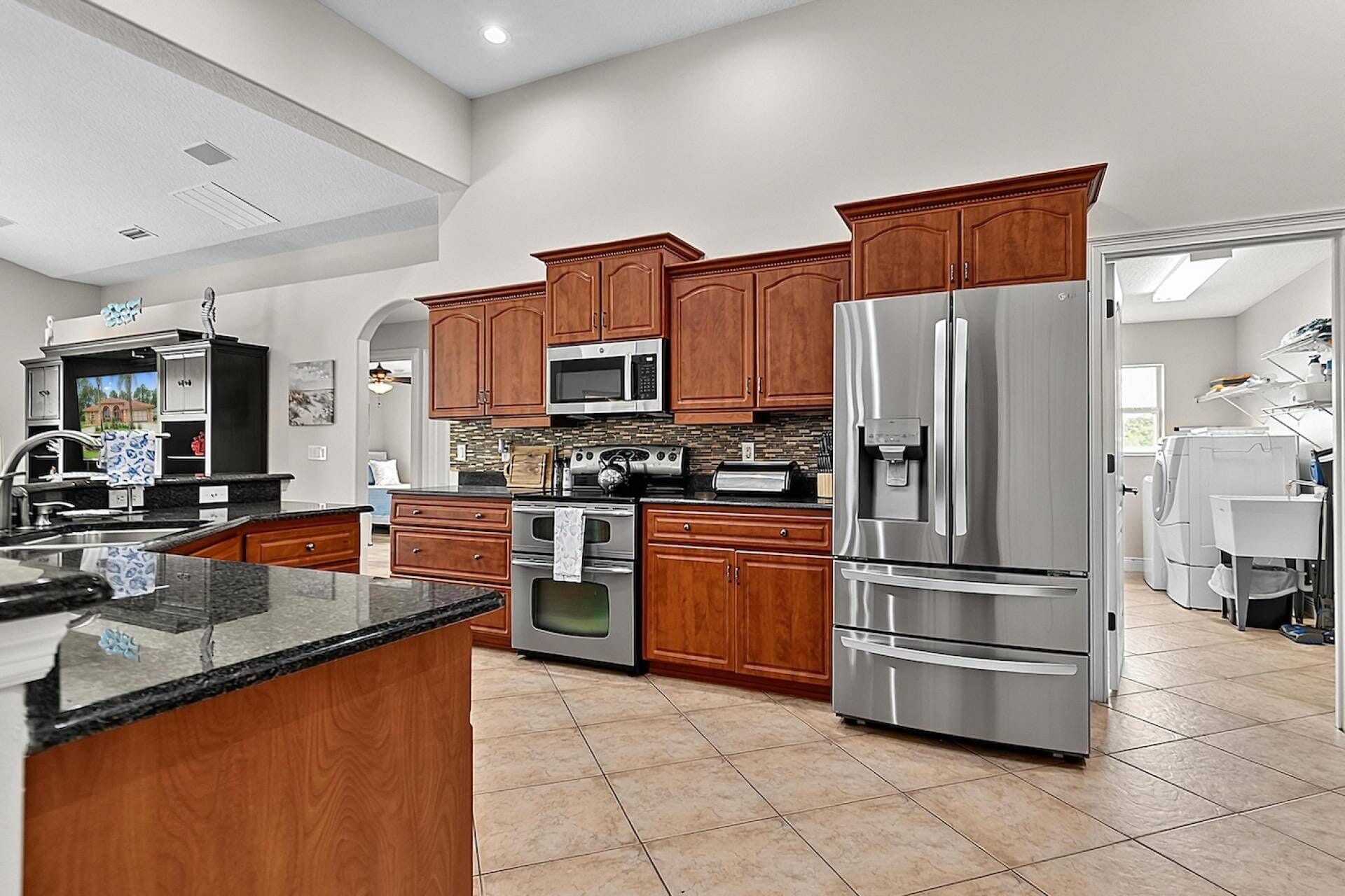 A modern kitchen with stainless steel appliances, wooden cabinets, and a large island.