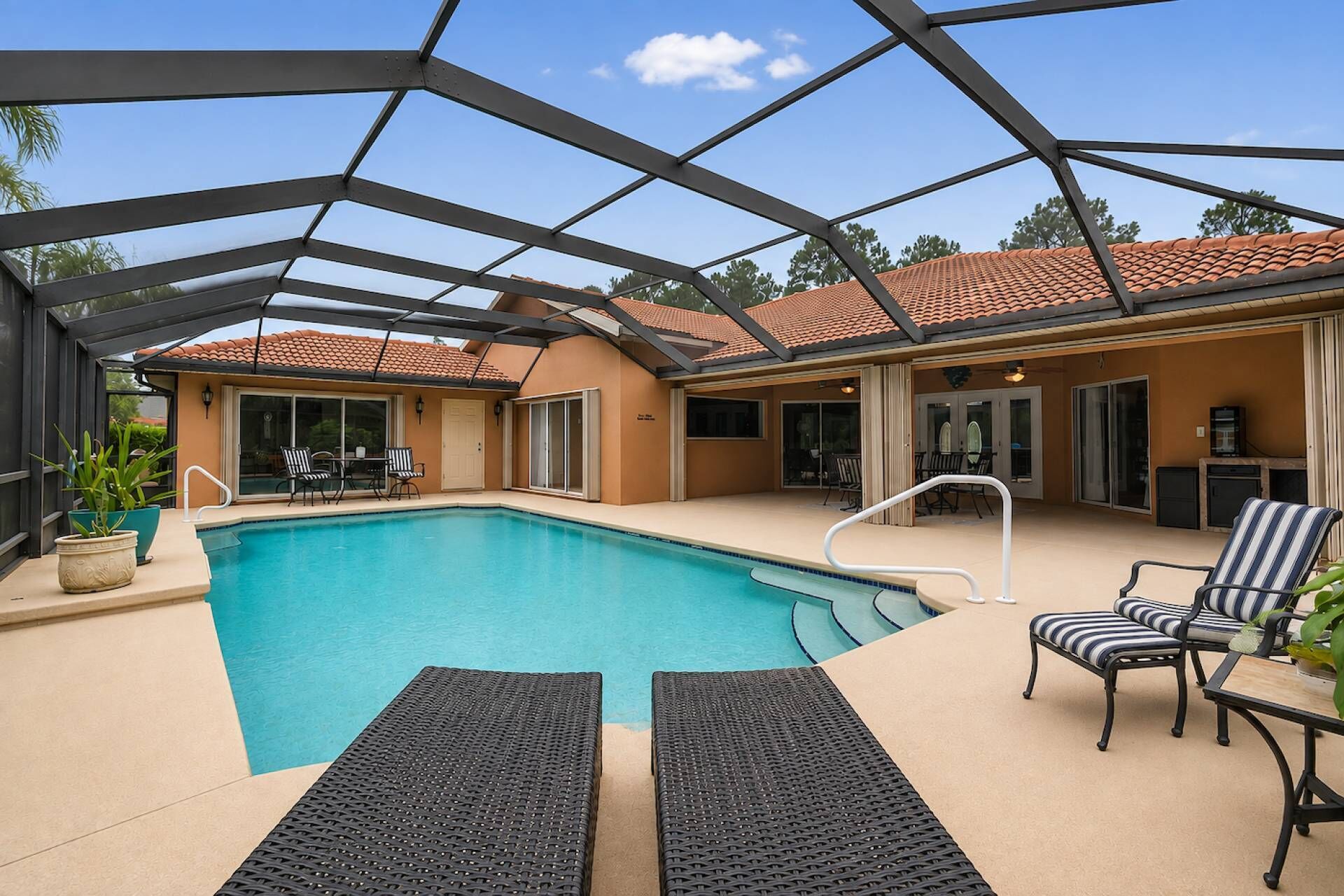 A covered outdoor swimming pool with lounge chairs and a patio area.