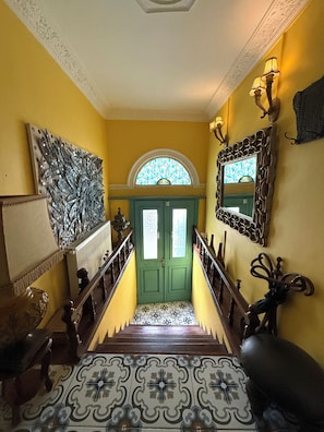 A staircase with a patterned floor leading to a green door with glass panels. - Historic Artistic House with Sea-View Terrace in Ayvalık (Balıkesir)