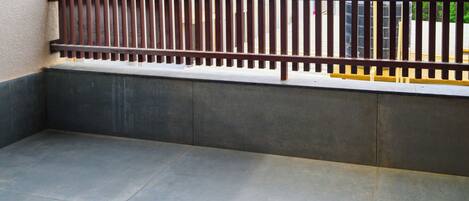 A corner of a room with a tiled floor and a metal fence.