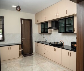 Una cocina moderna con encimera de mármol, estufa integrada y un lavamanos.