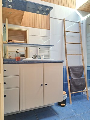 A bathroom with a wooden vanity, a mirror, a towel rack, and a blue-tiled floor. - TyRoch House in Huelgoat, near the forest and lake, in the heart of the Monts d'Arrée, with air conditioning (Huelgoat)