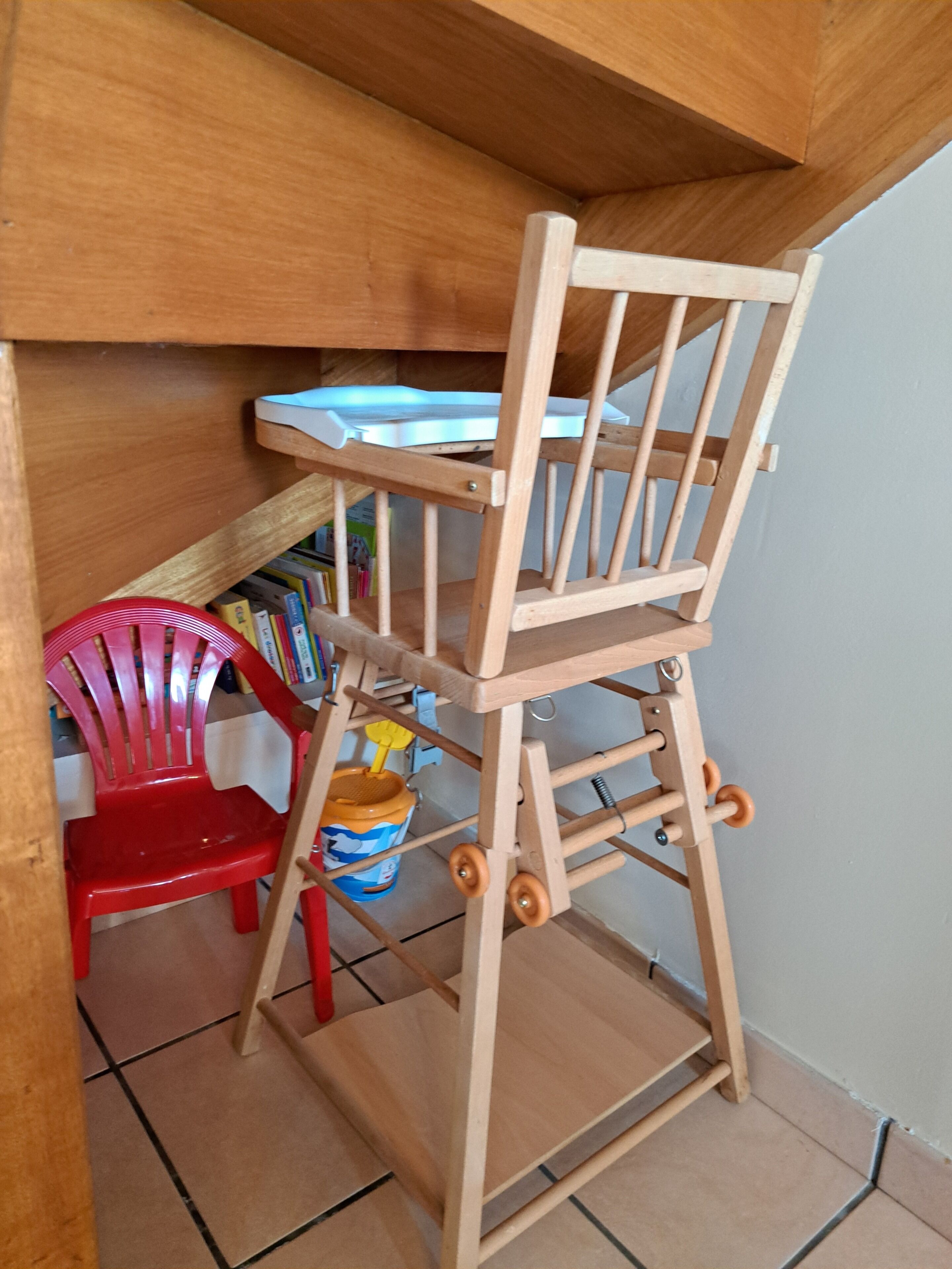 Een houten stoel met rugleuning en een opklapbaar trapje.