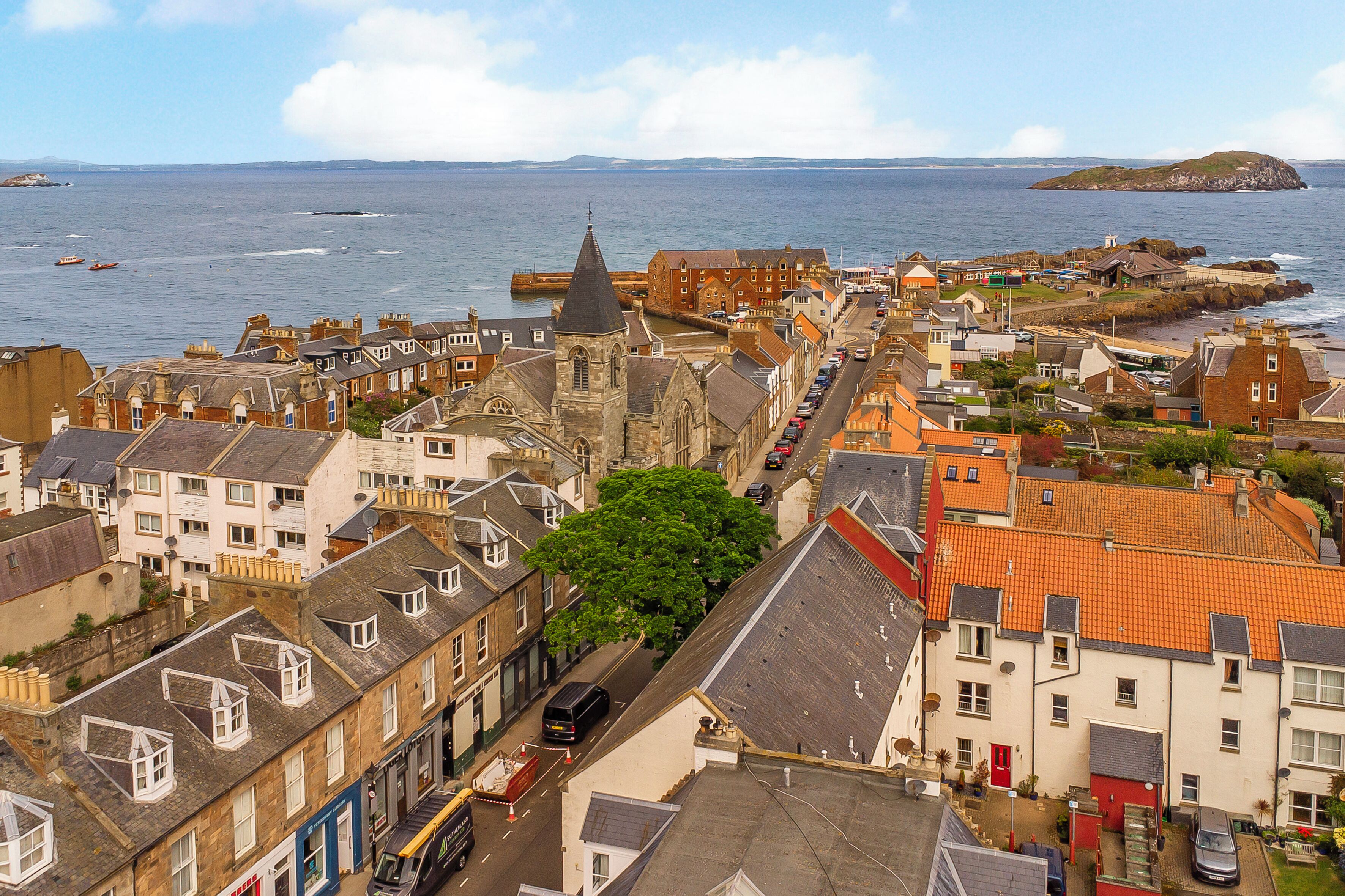 A coastal town with historic buildings, a harbor, and a view of the sea.