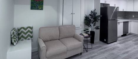 A modern living room with a sofa, a small table, and a potted plant.