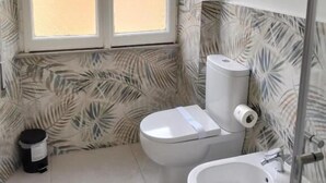 Ein Badezimmer mit Toilette, Bidet und Waschbecken.