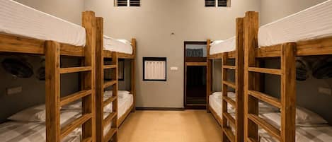 A room with bunk beds, a door, and a small window.