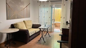 Uma sala de estar acolhedora com um sofá, uma mesinha e um objeto decorativo na parede.