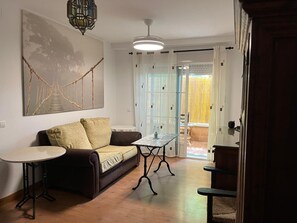 Ein gemütliches Wohnzimmer mit einer Couch, einem kleinen Tisch und einem Wandbild.