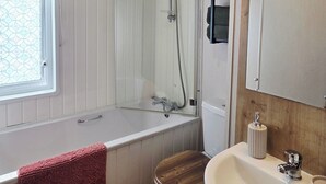A bathroom with a bathtub, toilet, and sink.