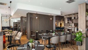Un restaurante moderno con mesas redondas, sillas y un patrón de suelo tipo espiga.