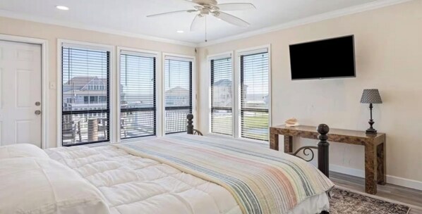 Una camera da letto con un letto, una scrivania, una televisione e un balcone vista.