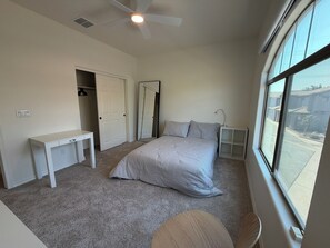 A bedroom with a bed, a desk, a chair, a wardrobe, a mirror, and a window with a view of the outside. - ASU Parent, Alumni, Sports Fan, Traveler - this is your place. (Tempe)