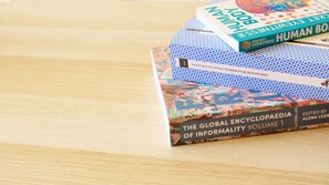 Ein Stapel Bücher auf einer Holztischfläche.