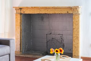 A fireplace with a brick interior and a yellow mantel. - [Historic Center] Elegant one-bedroom apartment with a balcony (Brescia)