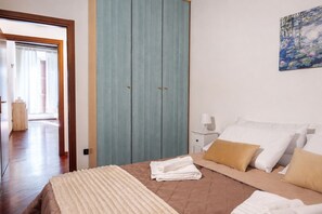 A bedroom with a bed, pillows, a bedside table, a nightstand, a wardrobe, and a painting on the wall. - [Historic Center] Elegant one-bedroom apartment with a balcony (Brescia)