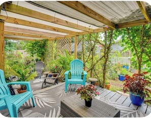 A covered patio area with wooden beams, outdoor furniture, and potted plants. - 'Palm Bungalow' Near Downtown St Augustine & Beaches! (St. Augustine)