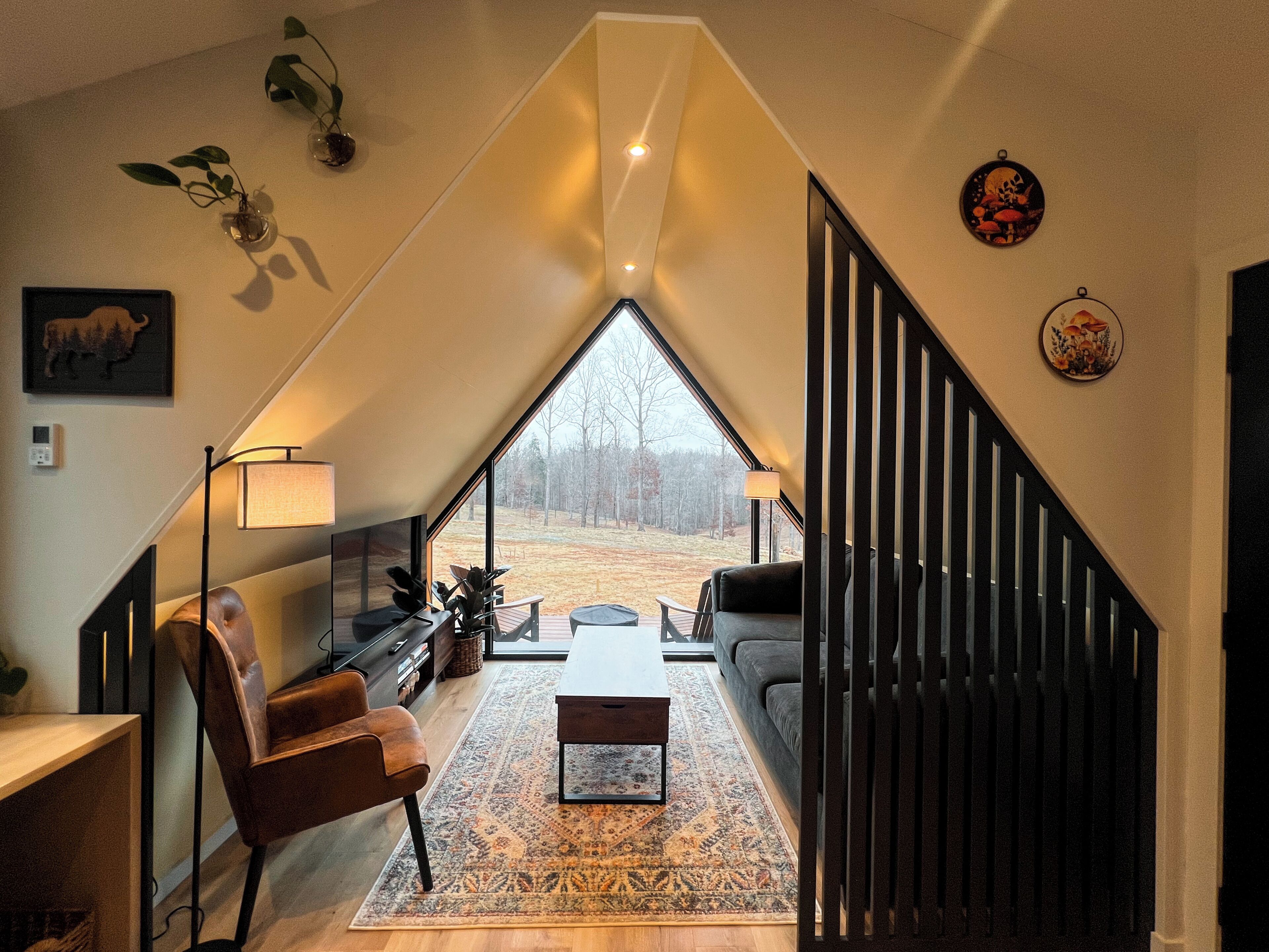 Un loft modern amb un gran lucernari, un sofà, una taula de cafè i una escala.