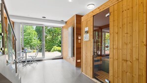 Et moderne interiør med en glasdør, der fører ud til en balkon, trævægge og et flisegulv.