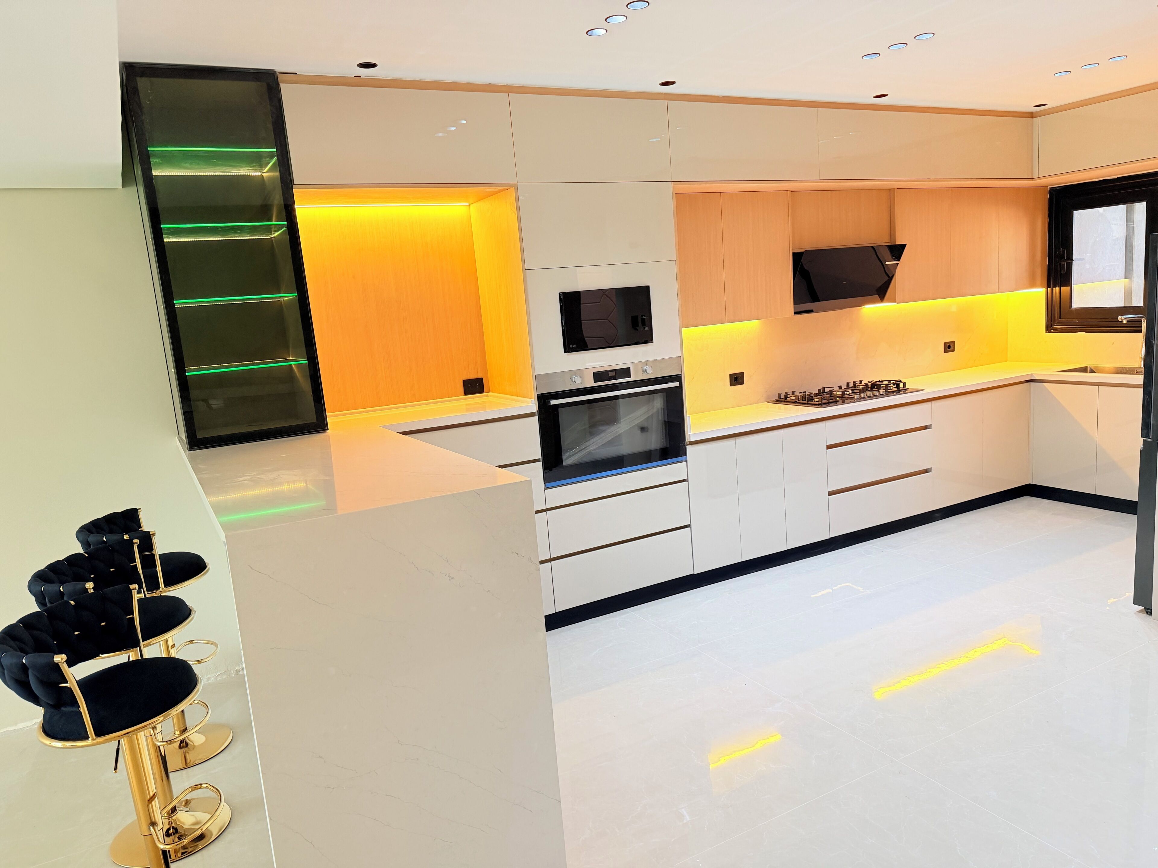 A modern kitchen with white cabinetry, a built-in oven, and a gas stove.