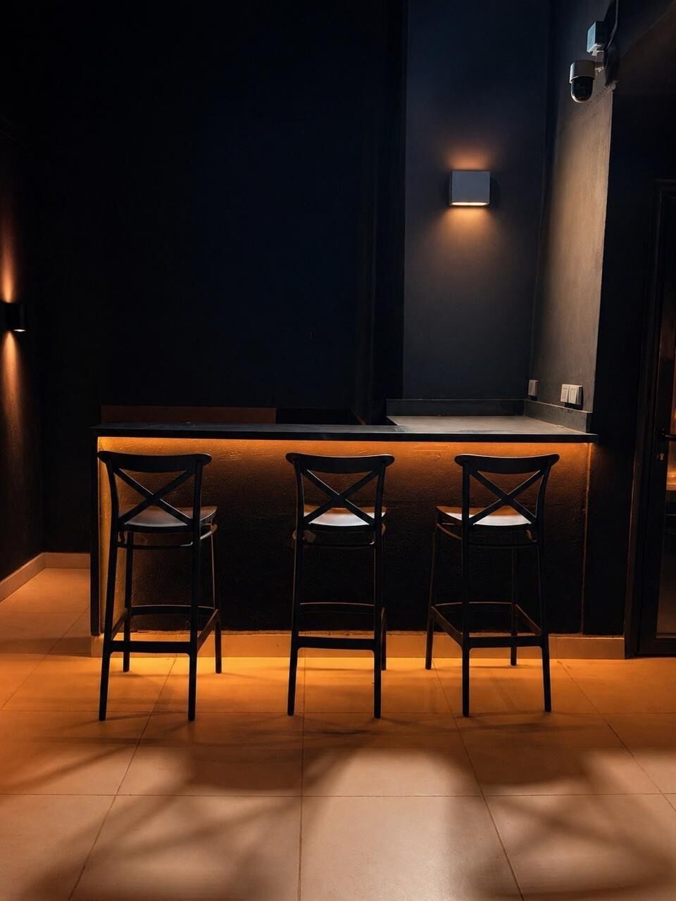 A bar area with three chairs and a counter.