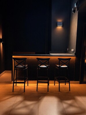 Zona de bar amb tres seients i una barra.