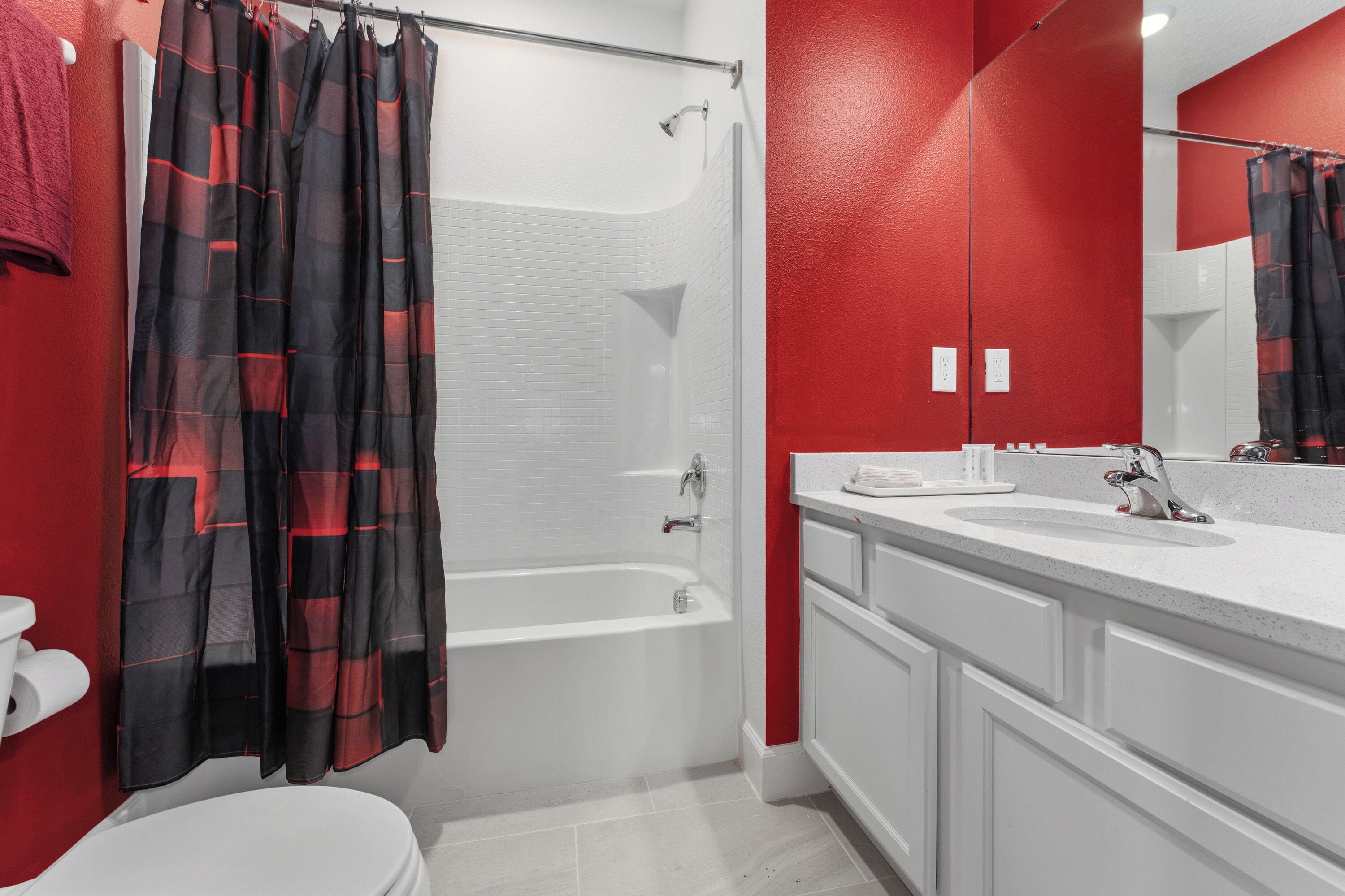 A bathroom with a shower, toilet, and sink.
