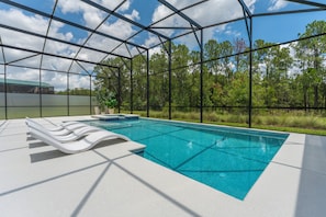 A swimming pool with lounge chairs and a greenhouse structure. - NEW Luxury 14BR Estate - Sleeps 36 - Theater/Games (Davenport)