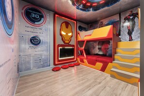A room with a bunk bed, a wall-mounted TV, and a red and yellow color scheme. - NEW Luxury 14BR Estate - Sleeps 36 - Theater/Games (Davenport)