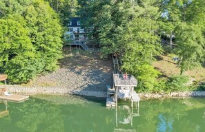 A lakeside property with a dock, a small pier, and a house in the background. - Sweetwater Cove:  3-Level Lakefront Retreat (Moneta)