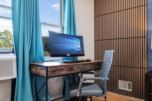 A modern office space with a wooden desk, a computer monitor, and a chair.