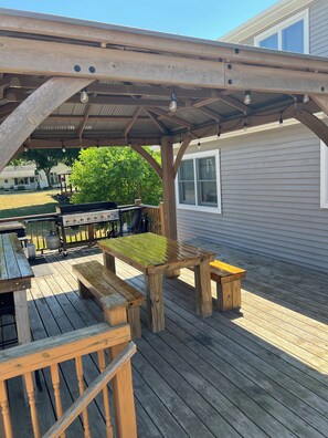 A wooden deck with a covered patio area, outdoor furniture, and a barbecue grill. - Marvelous 4-bedroom house with AC in charming Port Austin (Port Austin)