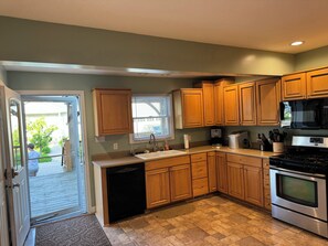A kitchen with wooden cabinets, a dishwasher, a sink, a stove, and a microwave. - Marvelous 4-bedroom house with AC in charming Port Austin (Port Austin)