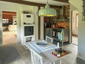 A kitchen with a brick wall, a stove, and a hanging light fixture. - Farmhouse with view towards Kullaberg (BÅSTAD)