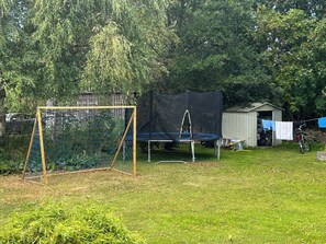 A backyard with a trampoline, a small shed, and a clothesline. - Farmhouse with view towards Kullaberg (BÅSTAD)