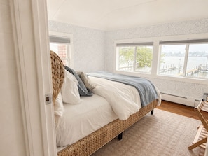 A bedroom with a bed, a window, and a view of a body of water. - Lakefront Retreat w/ 100' Private Dock - LEEHAVEN on Spring Lake (Spring Lake)