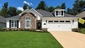 A two-story house with a stone facade, a garage, and a well-maintained lawn. - Exclusive Masters Retreat — Just Minutes from Augusta National (North Augusta)