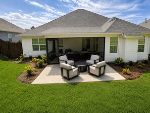 A house with a covered patio area featuring outdoor furniture. - Exclusive Masters Retreat — Just Minutes from Augusta National (North Augusta)