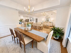 A spacious dining area with a wooden table, chairs, and a chandelier. - Exclusive Masters Retreat — Just Minutes from Augusta National (North Augusta)