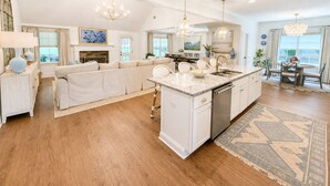 A spacious kitchen with a central island, white cabinetry, and a dining area with a round table and chairs. - Exclusive Masters Retreat — Just Minutes from Augusta National (North Augusta)
