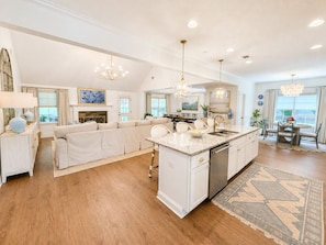A spacious kitchen with a central island, white cabinetry, and a dining area with a round table and chairs. - Exclusive Masters Retreat — Just Minutes from Augusta National (North Augusta)