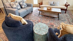 A living room with a sofa, armchair, coffee table, and ottoman. - Hallandale Hideaway, luxury townhome, sleeps 8 with POOL. (Murrells Inlet)