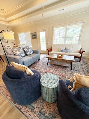 A living room with a sofa, armchair, coffee table, and ottoman. - Hallandale Hideaway, luxury townhome, sleeps 8 with POOL. (Murrells Inlet)