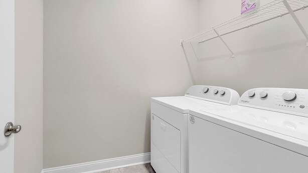 A laundry room with a front-loading washer and dryer, a metal drying rack, and a door. - Hallandale Hideaway, luxury townhome, sleeps 8 with POOL. (Murrells Inlet)