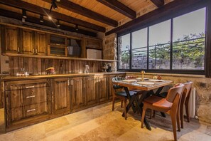 Una cocina rústica con armarios de madera, una mesa de comedor y sillas.