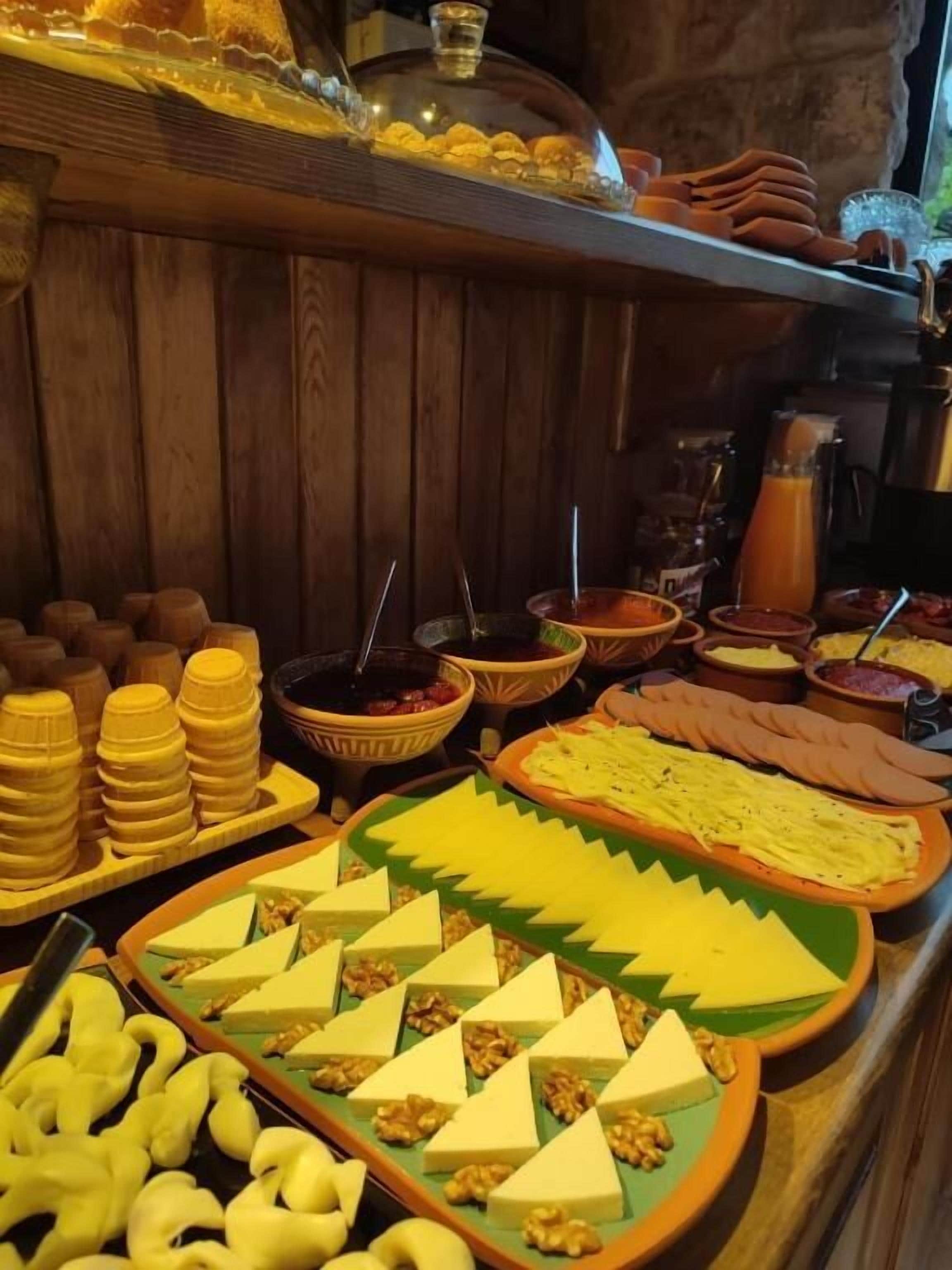 Ein reichhaltiges Buffet mit verschiedenen Speisen, darunter Käse, Nüsse und Früchte.