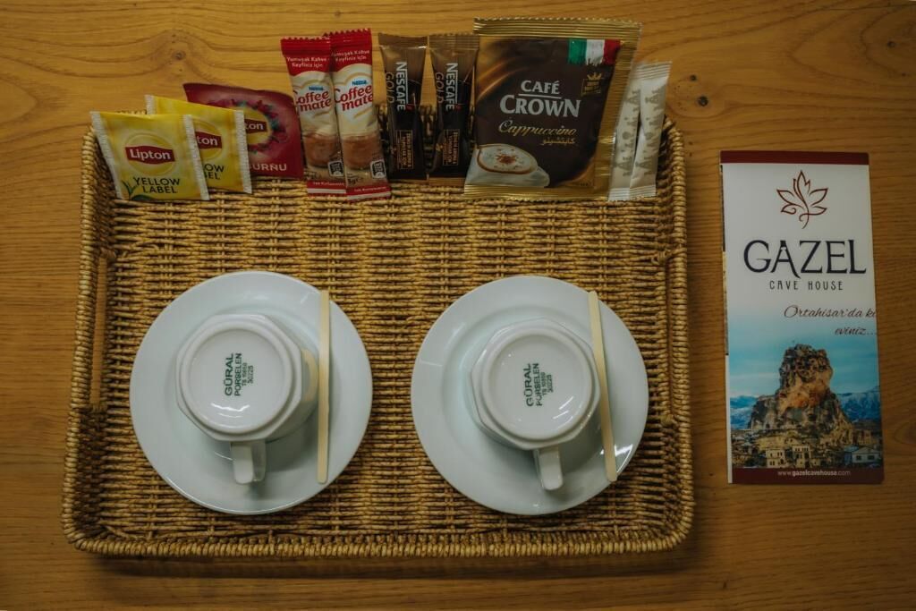 A tray with coffee packets, a Café Crown packet, two white cups, and a Gazel brochure.
